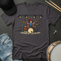 Dark gray t-shirt with a graphic of a person playing drums, accompanied by a cap and drum set on a dark surface.