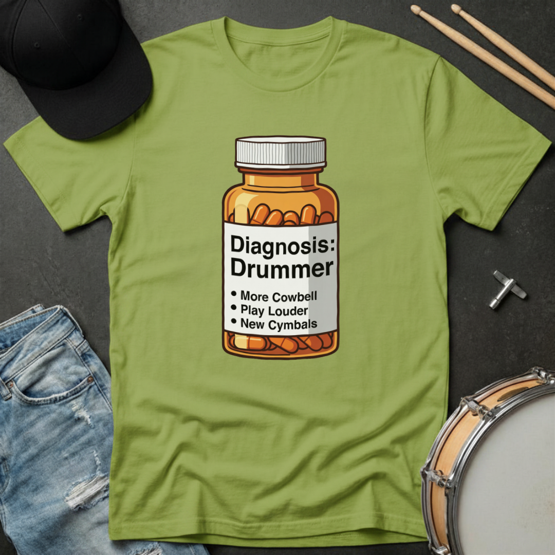 Green t-shirt with a bottle graphic and text 'Diagnosis: Drummer' on a dark surface with drumsticks and a cap.