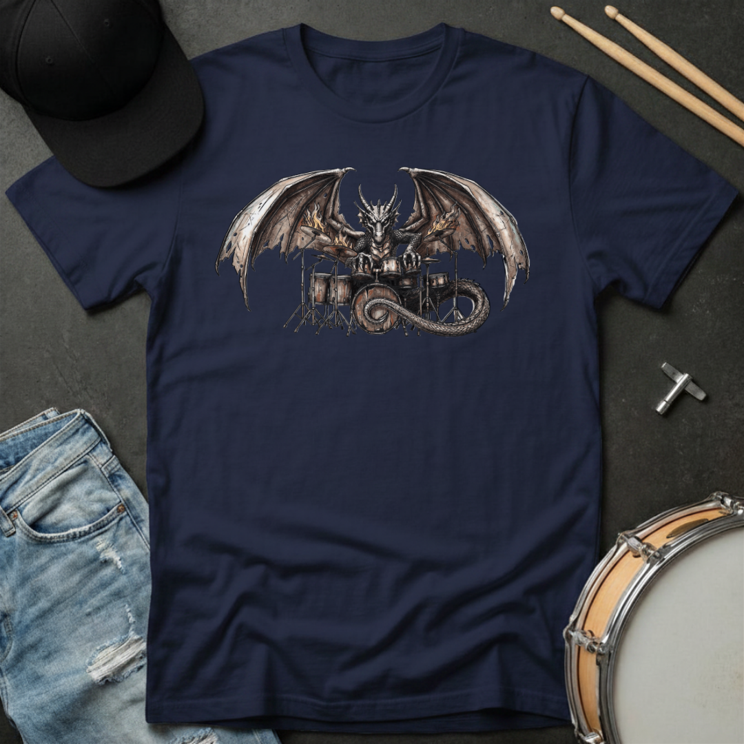 Navy blue t-shirt with dragon playing drums graphic on a dark surface with casual items.