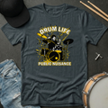 Gray t-shirt with drum design and text 'Drum Life Public Nuisance' on a dark surface with drumsticks and jeans.