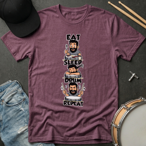 Maroon t-shirt with drum-themed graphic and text on a dark surface with casual items.