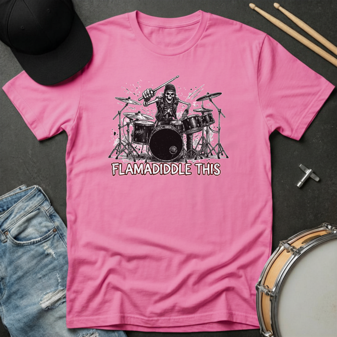Pink t-shirt with a graphic of a skeleton playing drums and text 'FLAMADIDDLE THIS' on a dark surface with drumsticks and jeans.