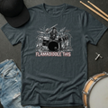 Gray t-shirt with a graphic of a drummer and 'Flamadiddle This' text, surrounded by casual items like jeans and a hat.