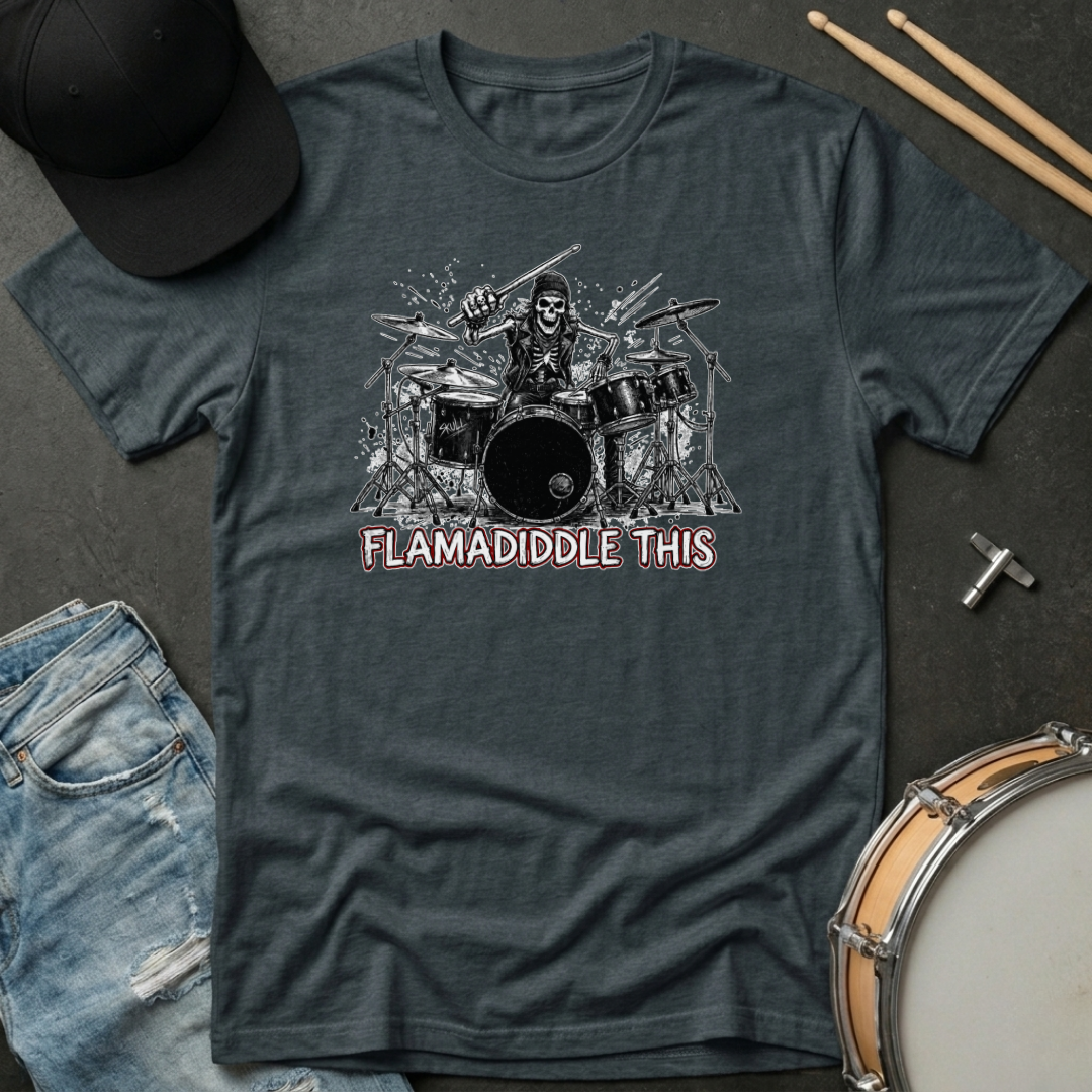 Gray t-shirt with a graphic of a drummer and 'Flamadiddle This' text, surrounded by casual items like jeans and a hat.