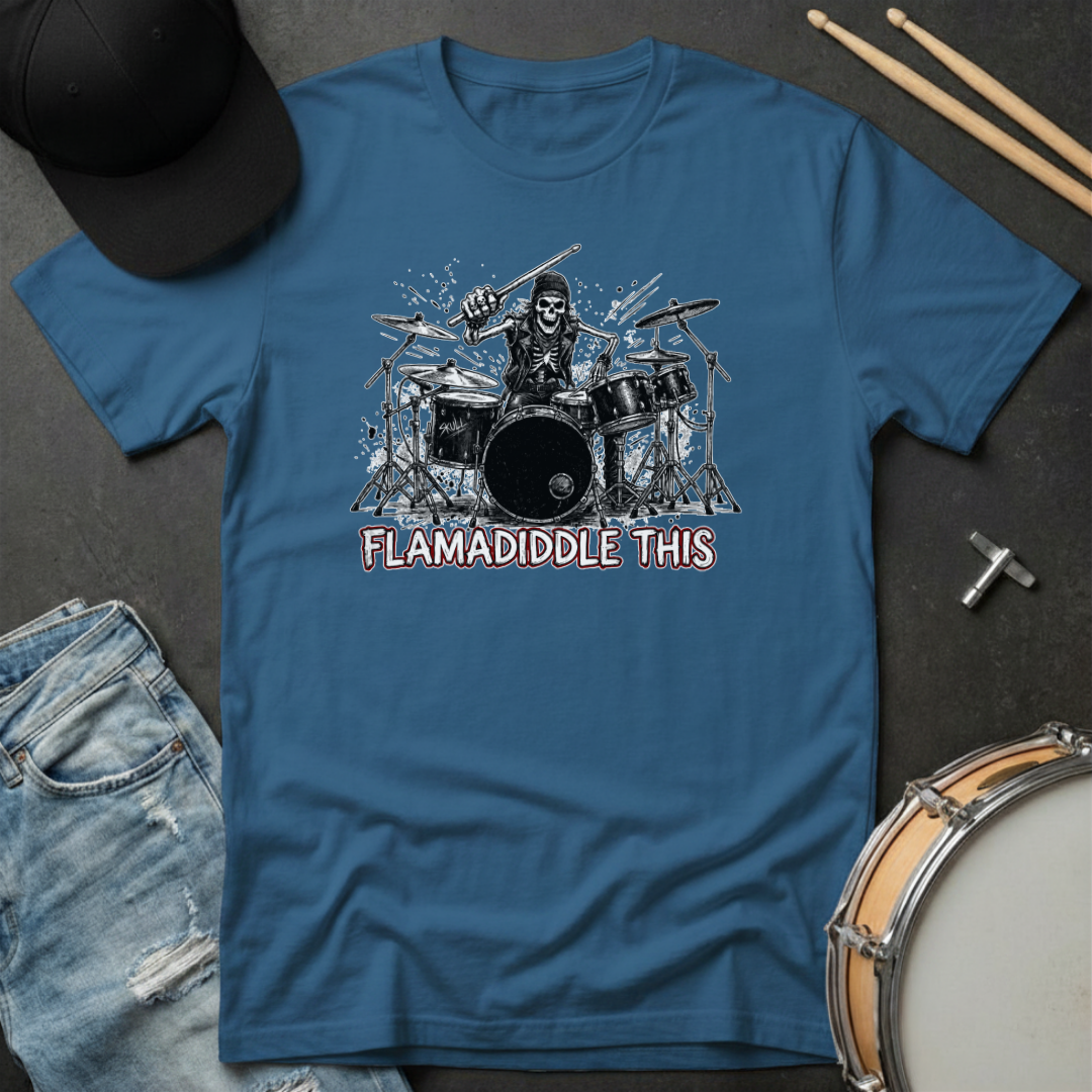 Blue t-shirt with a graphic of a skeleton playing drums and text 'FLAMADIDDLE THIS' on a dark surface with drumsticks and a cap.