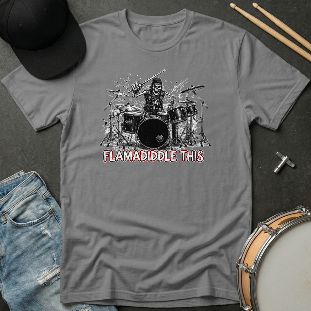 Gray t-shirt with a graphic of a drummer and text 'FLAMADIDDLE THIS' on a dark surface with drumsticks and jeans.