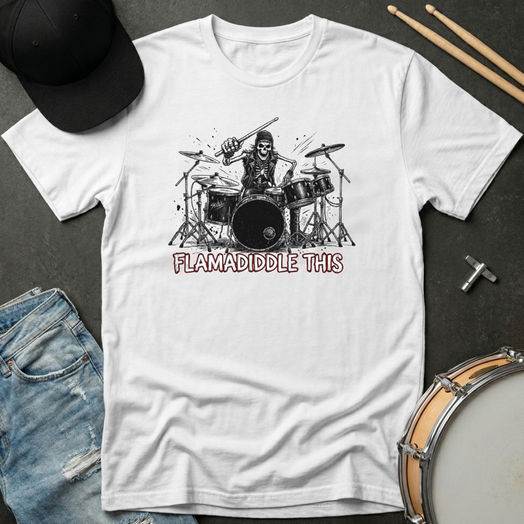 White t-shirt with a graphic of a drummer and text 'FLAMADIDDLE THIS' on a dark surface with drumsticks and jeans.