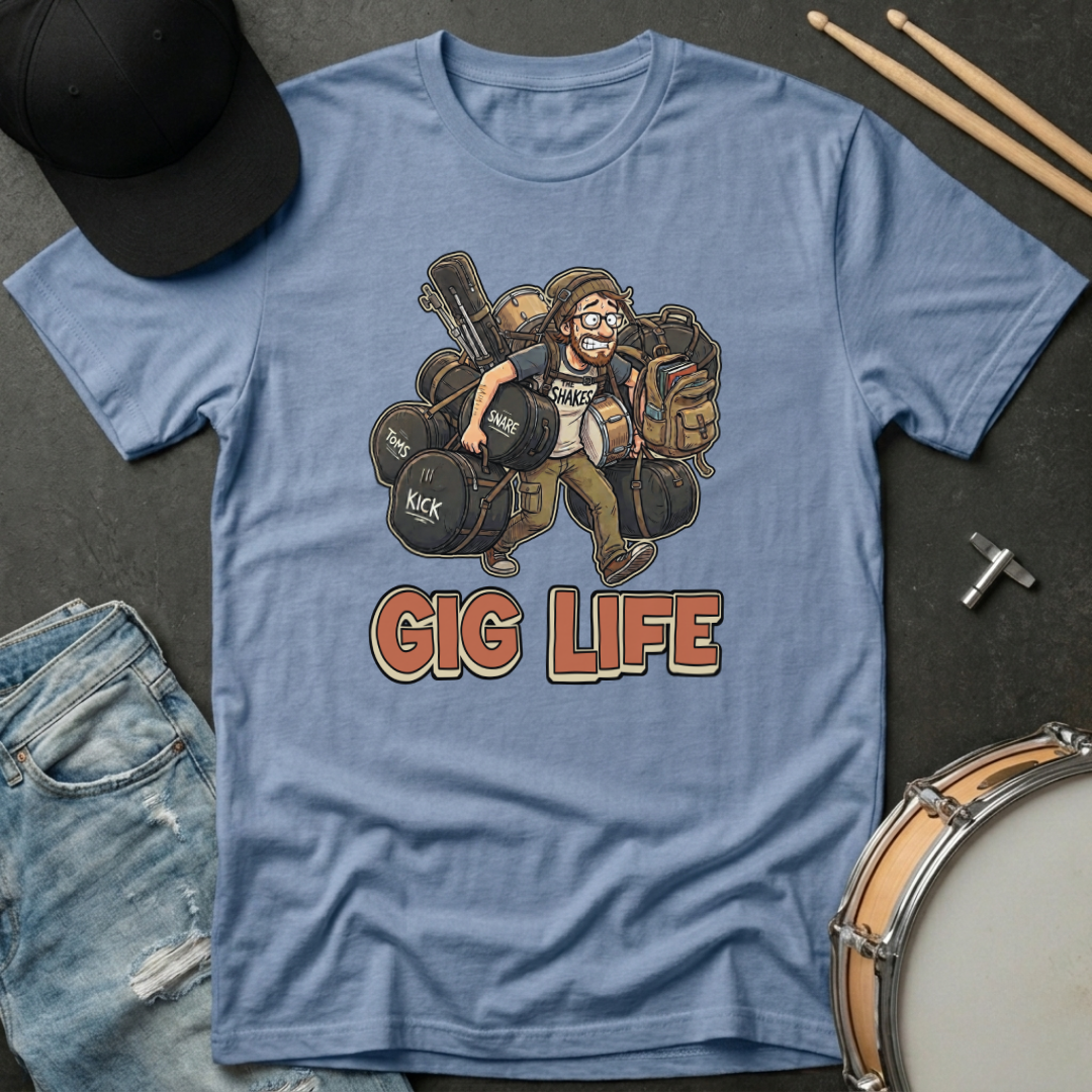 Blue t-shirt with 'Gig Life' graphic featuring a drummer, surrounded by drumsticks, cap, and jeans on a dark surface.
