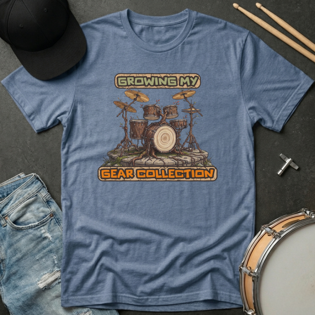 Blue t-shirt with drum set graphic and text 'Growing My Gear Collection' on a dark surface with accessories.