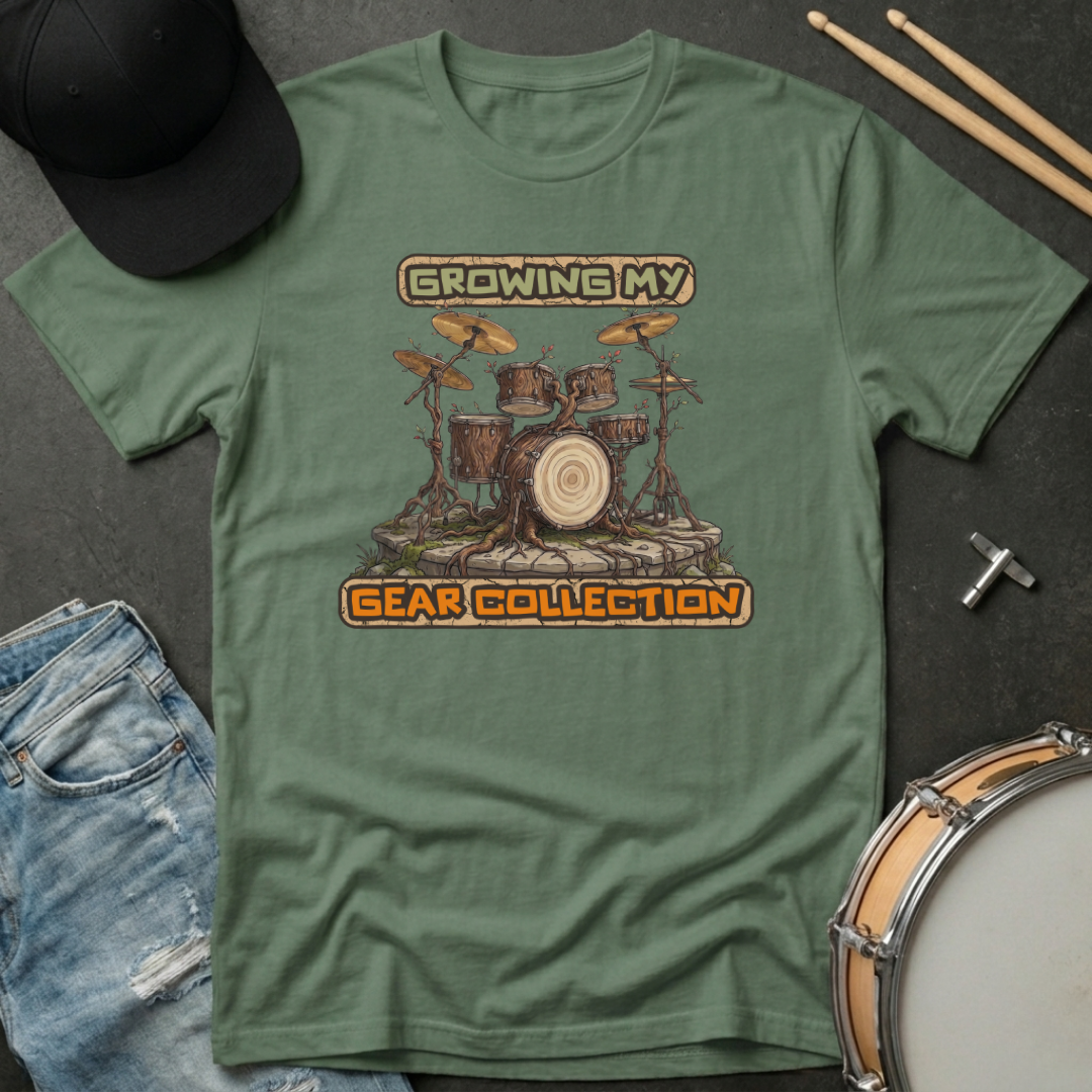 Green t-shirt with drum set graphic and text 'Growing My Gear Collection' on a dark surface with casual items.