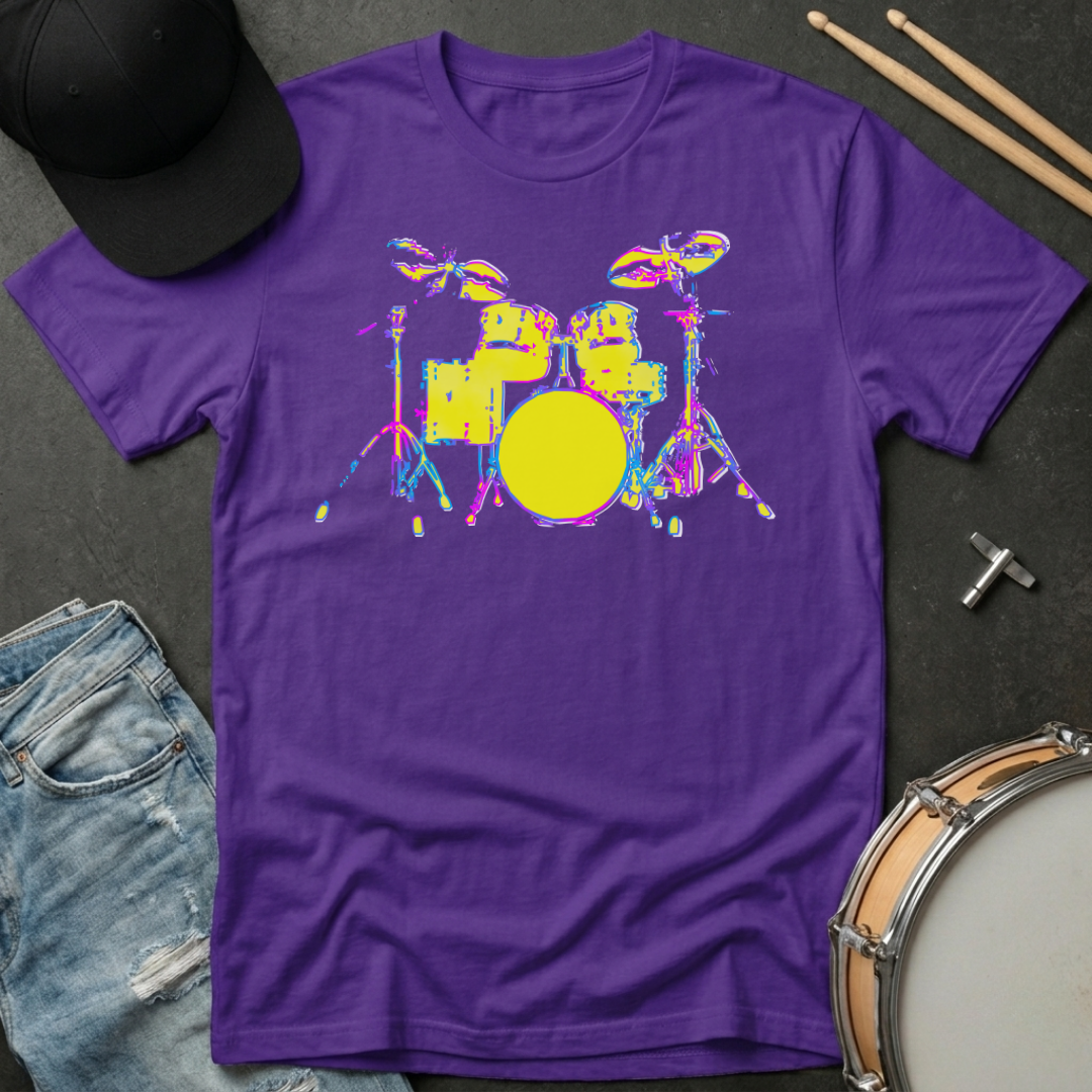 Purple t-shirt with colorful drum set graphic on a dark surface with denim jeans and drumsticks.