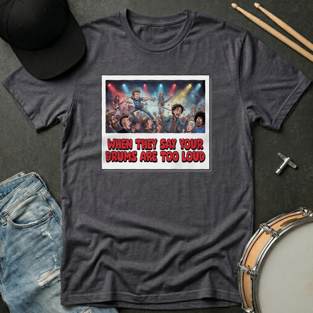 Gray t-shirt with graphic design and text on a dark surface with casual items.
